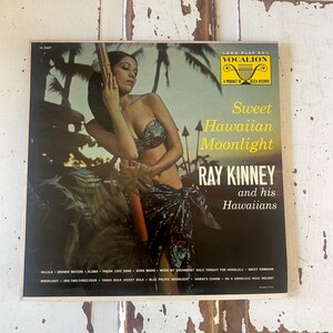 Peut inclure: Pochette d'album vinyle vintage pour "Sweet Hawaiian Moonlight" de Ray Kinney and his Hawaiians. La couverture présente une femme en bikini et sarong, avec du texte jaune et blanc. L'album est un produit de Decca Records.