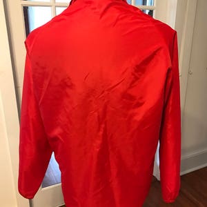 May include: A red lightweight jacket with a zipper closure and long sleeves.