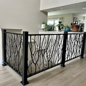 Könnte beinhalten: Schwarzes Metallgeländer mit einem Astdesign. Das Geländer ist an einer Treppe angebracht und bietet Sicherheit und Dekoration. Das Design hat eine moderne, künstlerische Ästhetik.