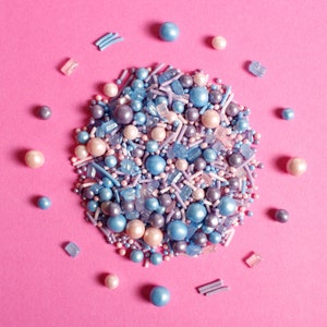 Purple, pink and blue cake sprinkles featuring edible sugar crystals, strands, nonpareils and pearls.