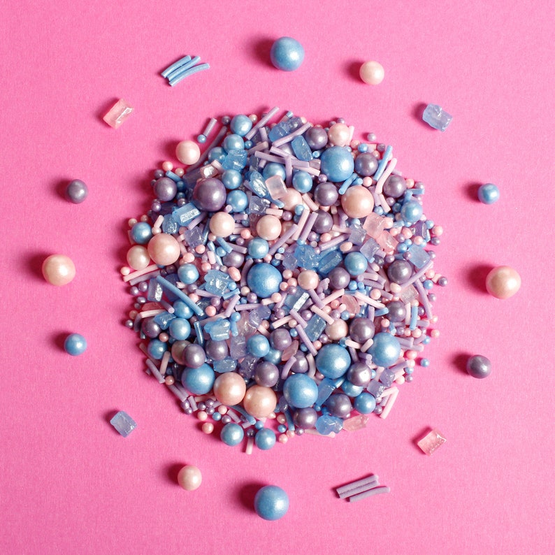 Purple, pink and blue cake sprinkles featuring edible sugar crystals, strands, nonpareils and pearls.