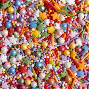 White, orange, red, purple, yellow, blue white cake sprinkles featuring edible sugar strands, nonpareils, sequins and pearls.