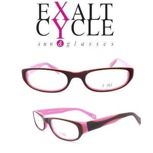 May include: Eyeglasses with dark brown frames and bright pink inner rims and temples. The text EXALT CYCLE sun & glasses is displayed above the eyewear. The right lens features the text E ME, and the word CYCLE is printed on the temple arm.