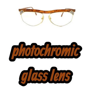 May include: Spectacles with a brown tortoiseshell browline frame, gold-tone metal rims, and clear lenses. The temples feature small, triangular accents embedded with tiny clear crystals. The text "photochromic glass lens" appears below.