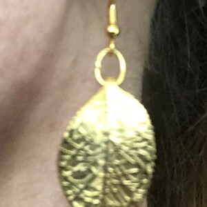 Puede incluir: Pendientes de hoja de oro con superficie texturizada.