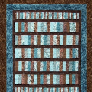 May include: A quilt pattern called "Fiddlesticks" by Pressed For Time Quiltworks. The pattern is a fat quarter friendly pattern and features a brown and blue color scheme.