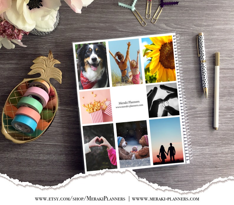May include: A spiral-bound planner with a collage of photos, including a dog, people at the beach, a sunflower, and a couple at sunset. A gold pineapple-shaped dish holds colorful washi tape rolls. Two pens and paper clips are also visible.