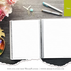 May include: Open spiral-bound notebook with lined pages, black and white striped border, and a silver spiral. The notebook is on a dark wood surface with pens, paper clips, and decorative tape. The word "Notes" is visible.