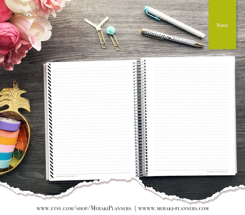 May include: Open spiral-bound notebook with lined pages, black and white striped border, and a silver spiral. The notebook is on a dark wood surface with pens, paper clips, and decorative tape. The word "Notes" is visible.