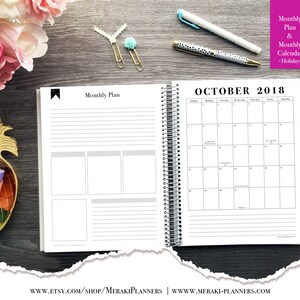 May include: Open spiral-bound planner with a monthly plan and calendar for October 2018. The planner includes lined pages and boxes for notes. The text "Monthly Plan & Monthly Calendar + Holidays" is visible. Pens and decorative paper clips are also present.