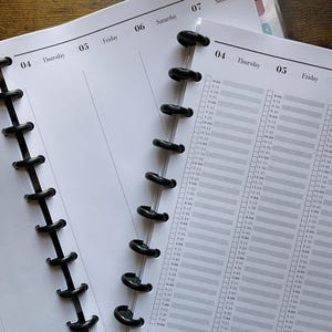 May include: Close-up of open planner pages with a black disc-bound spine. The pages are white with gray grid lines and time slots. The top of the page shows the days of the week, with "Thursday" and "Friday" visible. The planner is open to "Week 36".