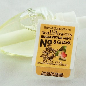 May include: A yellow and white label with the text "Bath & Body Works wallflowers EUCALYPTUS MINT NO & GUAVA" and a picture of a guava. The label also says "0.8 fl oz / 24 mL HOME FRAGRANCE REFILL". There is a clear glass bottle with a white cap.