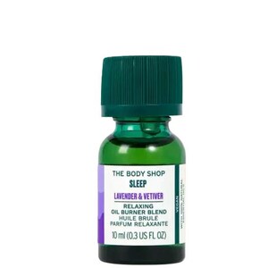 May include: A green glass bottle with a green lid containing The Body Shop Sleep Lavender & Vetiver Relaxing Oil Burner Blend. The bottle is labelled with the text "10 ml (0.3 US FL OZ)" and "VEGAN".