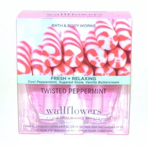 May include: A pink and white box of wallflower home fragrance refills with a peppermint candy cane design. The box says "Twisted Peppermint" and "Fresh + Relaxing" with the scent description "Cool Peppermint, Sugared Snow, Vanilla Buttercream".