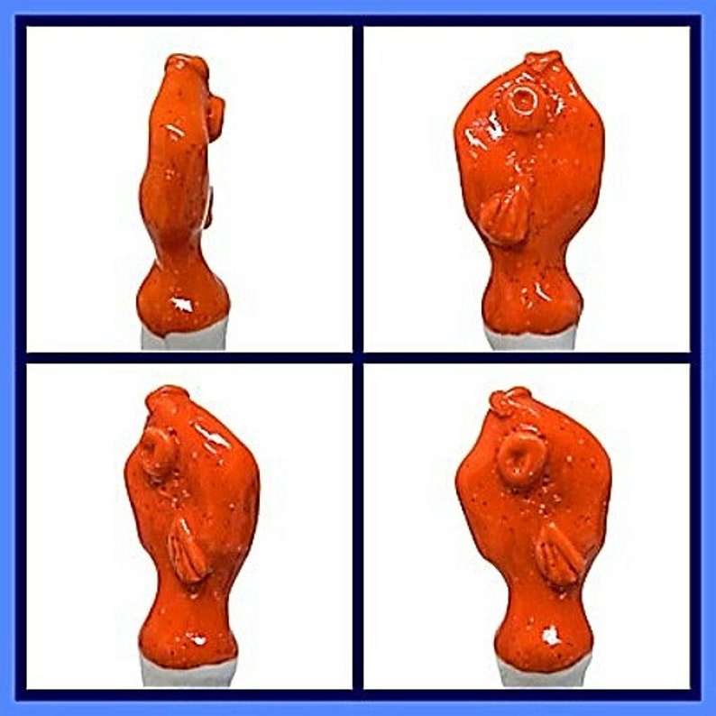 Peut inclure: Quatre vues d'un bouchon de bouteille en c&eacute;ramique en forme de poisson. Le bouchon de bouteille est orange et a une finition brillante.
