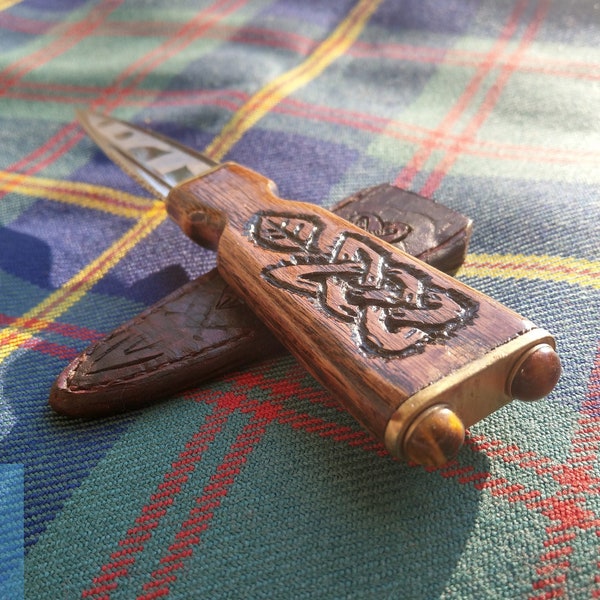 Sgain dubh of oak with knot work and a hand etched blade. No one in a kilt is properly attired without one. Custom made, one of a kind.