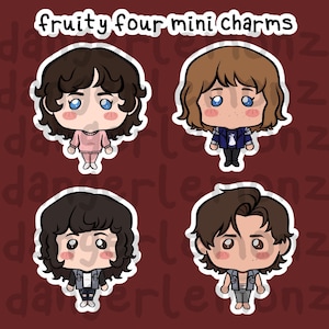 May include: Four mini charm stickers with cartoon illustrations of characters. The stickers have a white border and are on a maroon background. The text "fruity four mini charms" is at the top. Each character has a unique hairstyle and outfit.
