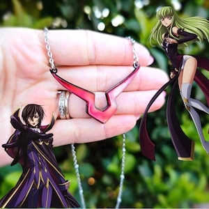 Könnte beinhalten: Eine silberne Kettenkette mit einem roten und rosafarbenen Metallanhänger in Form des Symbols aus der Anime-Serie Code Geass. Der Anhänger hat die Form eines V mit einem kleineren V darin.