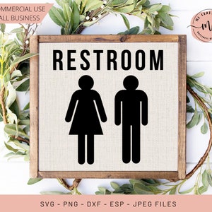 May include: A wooden sign with the word "RESTROOM" in black text.  The sign also features black silhouette icons of a woman and a man.