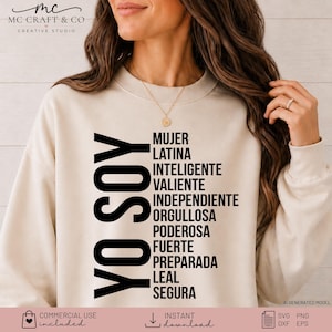 May include: A beige crewneck sweatshirt featuring black text that reads YO SOY MUJER LATINA INTELIGENTE VALIENTE INDEPENDIENTE ORGULLOSA PODEROSA FUERTE PREPARADA LEAL SEGURA. The garment has long sleeves and a ribbed neckline, cuffs, and hem.