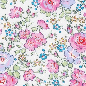 Puede incluir: Tela floral con fondo blanco, con un patrón de flores rosas, azules y amarillas y hojas verdes. El diseño incluye rosas y flores más pequeñas, creando una estética clásica y femenina. La tela tiene una regla con centímetros.