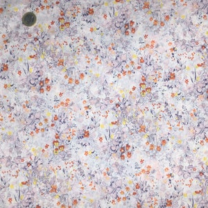 Peut inclure: Un tissu floral avec un fond blanc et un motif de petites fleurs dans des tons orange, violet et jaune. Le motif est dense et recouvre toute la surface, créant un aspect délicat et complexe. Le tissu semble léger.