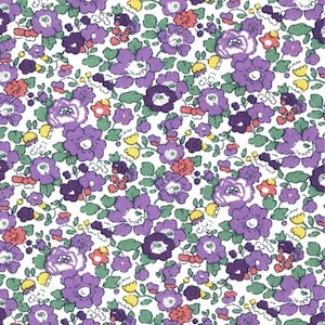 Può includere: Un motivo in tessuto caratterizzato da una fitta stampa floreale su sfondo bianco. Il design è composto da fiori in varie tonalità di viola, piccoli boccioli gialli e minuscoli fiori color corallo, intervallati da foglie e steli verdi.