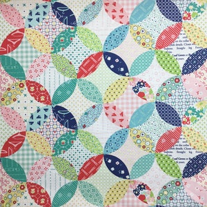 Peut inclure: Une courtepointe patchwork colorée avec un motif floral et géométrique. La courtepointe présente divers tissus dans des tons de rouge, rose, bleu, vert et jaune. Certains morceaux de tissu ont du texte imprimé.