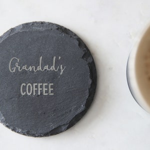 Puede incluir: Un posavasos de pizarra negra con las palabras "Grandad's Coffee" grabadas en blanco.