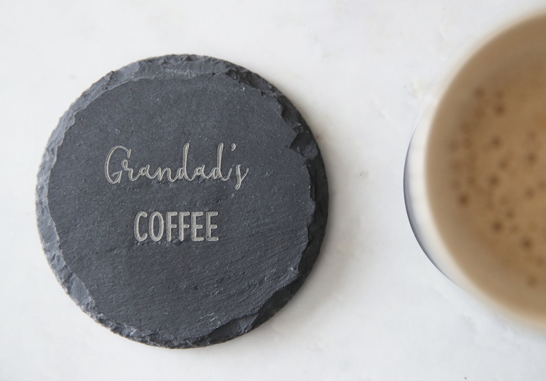 Puede incluir: Un posavasos de pizarra negra con las palabras "Grandad's Coffee" grabadas en blanco.