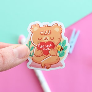 Self Love Club avec Paco l'ours, autocollant imperméable brillant en vinyle découpé pour bouteille d'eau, ordinateur portable et plus illustré par Ilariapops.