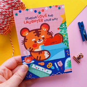 A6 Cute Bao the Tiger Christmas Postcard - "Sending Love and Laughter" printed on a 350g matt paper, 105x148mm