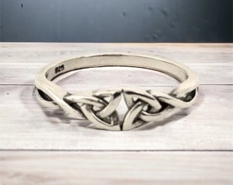 May include: A silver Celtic knot ring with a braided design. The ring is made of sterling silver and has a polished finish.