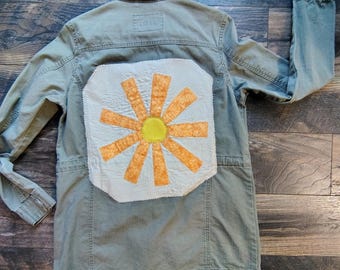 Giacca in denim riciclato con applicazioni, verde militare effetto invecchiato, leggera e adatta alla primavera.