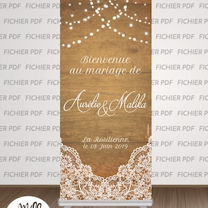 May include: A wedding backdrop with a rustic wood background and white lace trim. The text "Bienvenue au mariage de Aurelie & Malika" is displayed in black text. The date "La Rosilienne, le 08 Juin 2019" is also displayed in black text. The backdrop is decorated with white string lights.