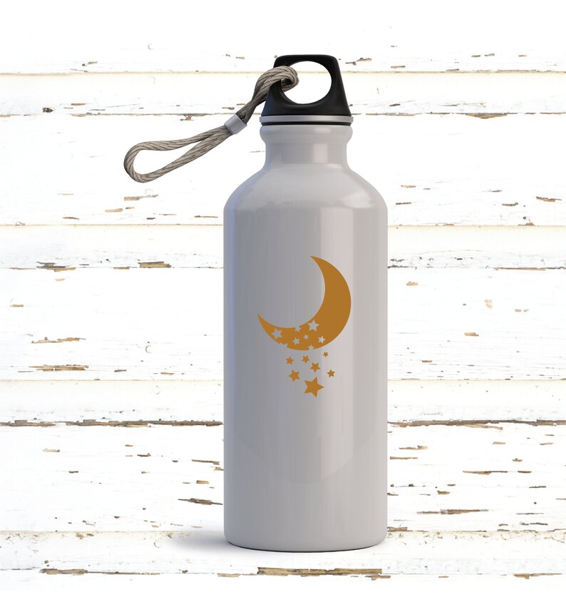 Puede incluir: Una botella de agua de aluminio blanca con tapa negra y asa de cuerda. La botella tiene un dise&ntilde;o de media luna dorada y estrellas.