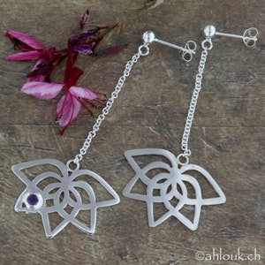 May include: A pair of silver dangle earrings with a delicate chain and a floral design. Each earring features a small purple gemstone in the center of the flower.