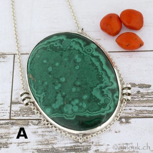 Puede incluir: Un collar de cadena de plata con un gran colgante ovalado de malaquita verde. El colgante tiene un patr&oacute;n de remolino de verde y blanco.