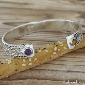 Puede incluir: Pulsera de plata con un dise&ntilde;o tejido y dos acentos de piedras preciosas. Una piedra es p&uacute;rpura y la otra es &aacute;mbar.