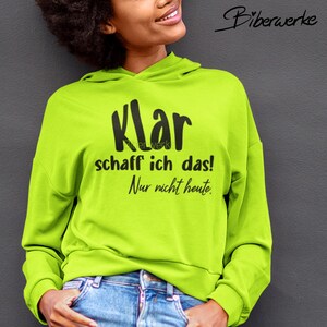 Könnte beinhalten: Ein neongrüner Hoodie mit schwarzem Text, der "Klar schaff ich das! Nur nicht heute." lautet.