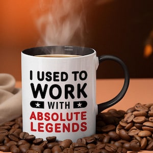 May include: White coffee mug with a black rim and handle. The mug has black text that reads "I used to work with absolute legends".