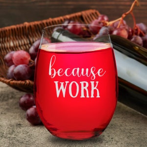 Puede incluir: Una copa de vino tinto con el texto "because work" impreso en ella. La copa está llena de vino tinto y está sobre una superficie de madera.