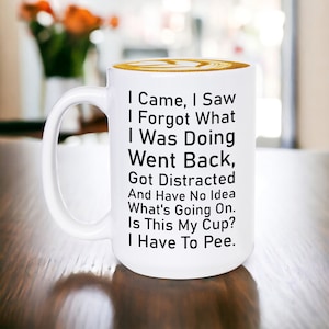 May include: White ceramic coffee mug with black text that reads "I Came, I Saw, I Forgot What I Was Doing, Went Back, Got Distracted And Have No Idea What's Going On. Is This My Cup? I Have To Pee."