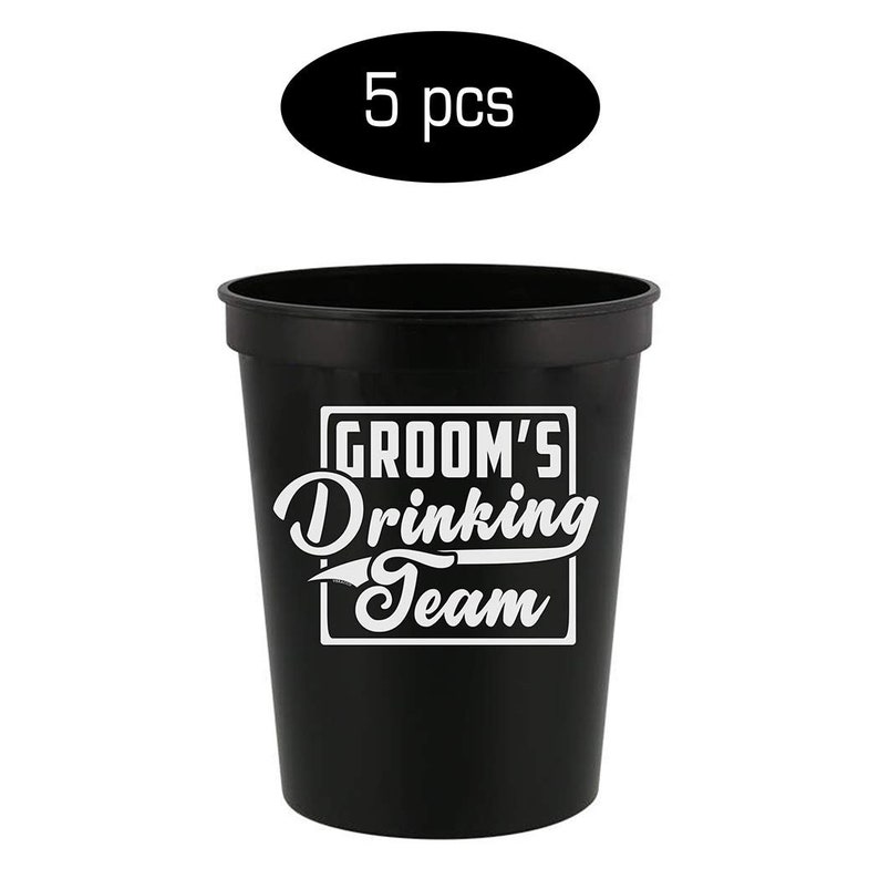 May include: Set of five black plastic cups with white text that reads "Groom's Drinking Team".