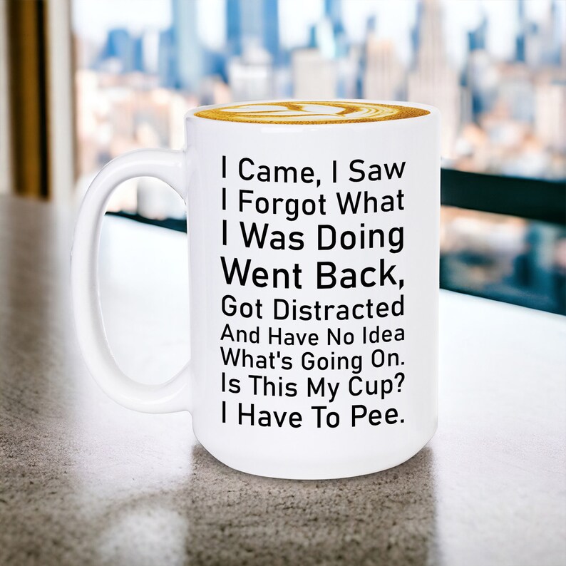 May include: White ceramic coffee mug with black text that reads: "I Came, I Saw, I Forgot What I Was Doing, Went Back, Got Distracted And Have No Idea What's Going On. Is This My Cup? I Have To Pee."