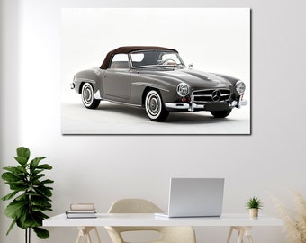 Könnte beinhalten: Gerahmter Leinwanddruck eines klassischen grauen Cabriolets mit braunem Verdeck. Das Auto hat Weißwandreifen und Chromakzente. Das Kunstwerk wird an einer weißen Wand über einem Schreibtisch mit Laptop und Topfpflanze gezeigt.