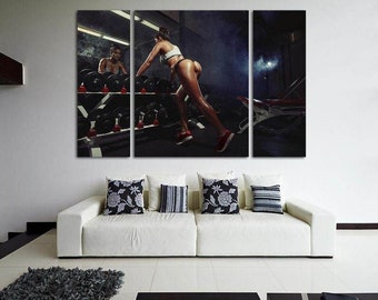 May include: A woman in a white sports bra and black underwear is lifting weights in a gym. She is standing on a platform with a barbell in front of her. The gym is dark and there are mirrors on the walls.