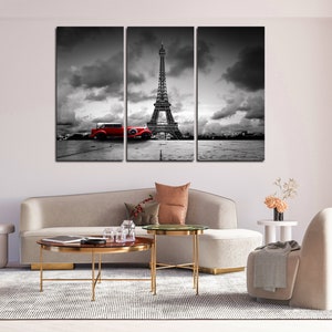 Puede incluir: Una impresi&oacute;n en lienzo de tres paneles con una imagen en blanco y negro de la Torre Eiffel en Par&iacute;s, Francia. Un coche vintage rojo est&aacute; aparcado en primer plano.