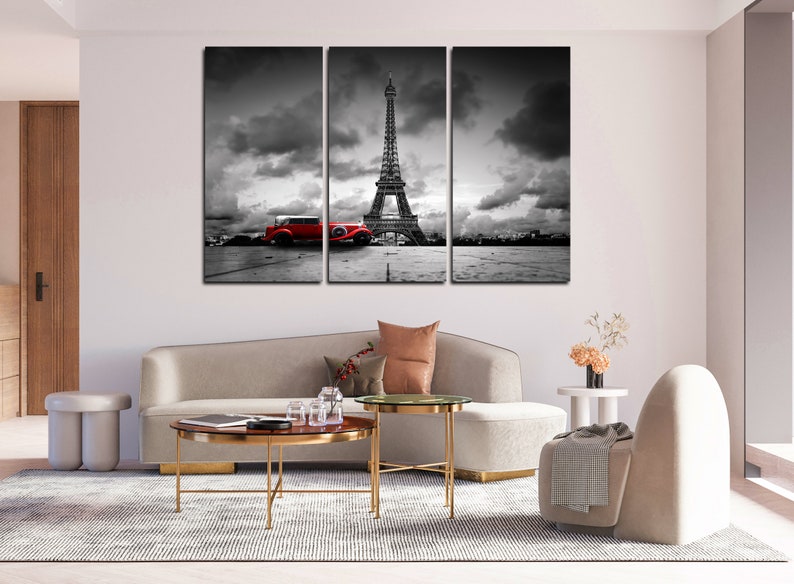 Puede incluir: Una impresi&oacute;n en lienzo de tres paneles con una imagen en blanco y negro de la Torre Eiffel en Par&iacute;s, Francia. Un coche vintage rojo est&aacute; aparcado en primer plano.