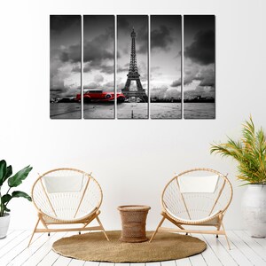 Puede incluir: Una impresi&oacute;n en lienzo en blanco y negro de la Torre Eiffel en Par&iacute;s, Francia. Un coche rojo vintage est&aacute; aparcado frente a la torre. La impresi&oacute;n est&aacute; dividida en cinco paneles.